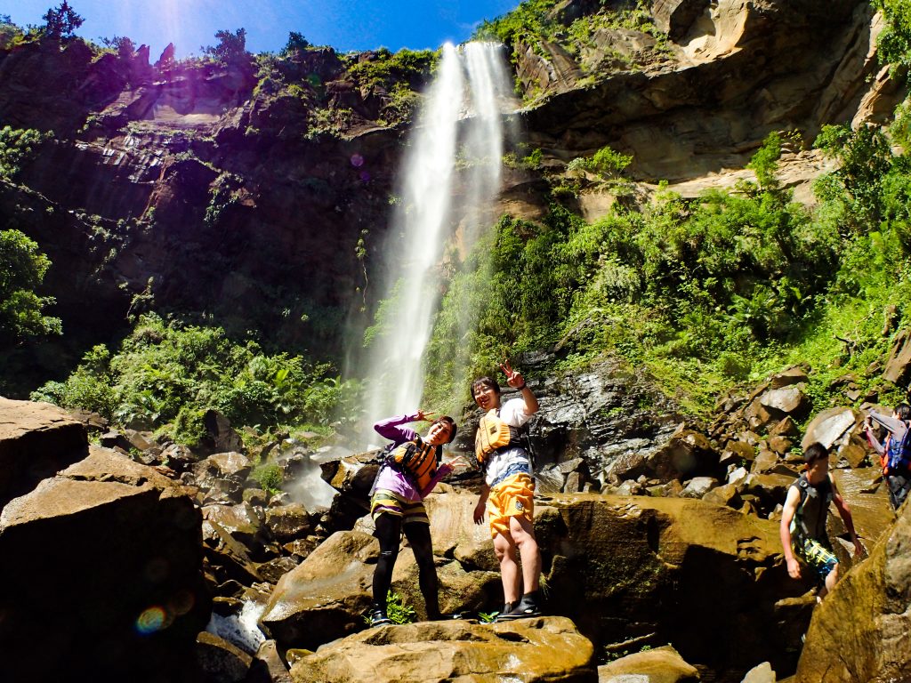 沖縄県下一の落差を持つピナイサーラの滝前で写真撮影