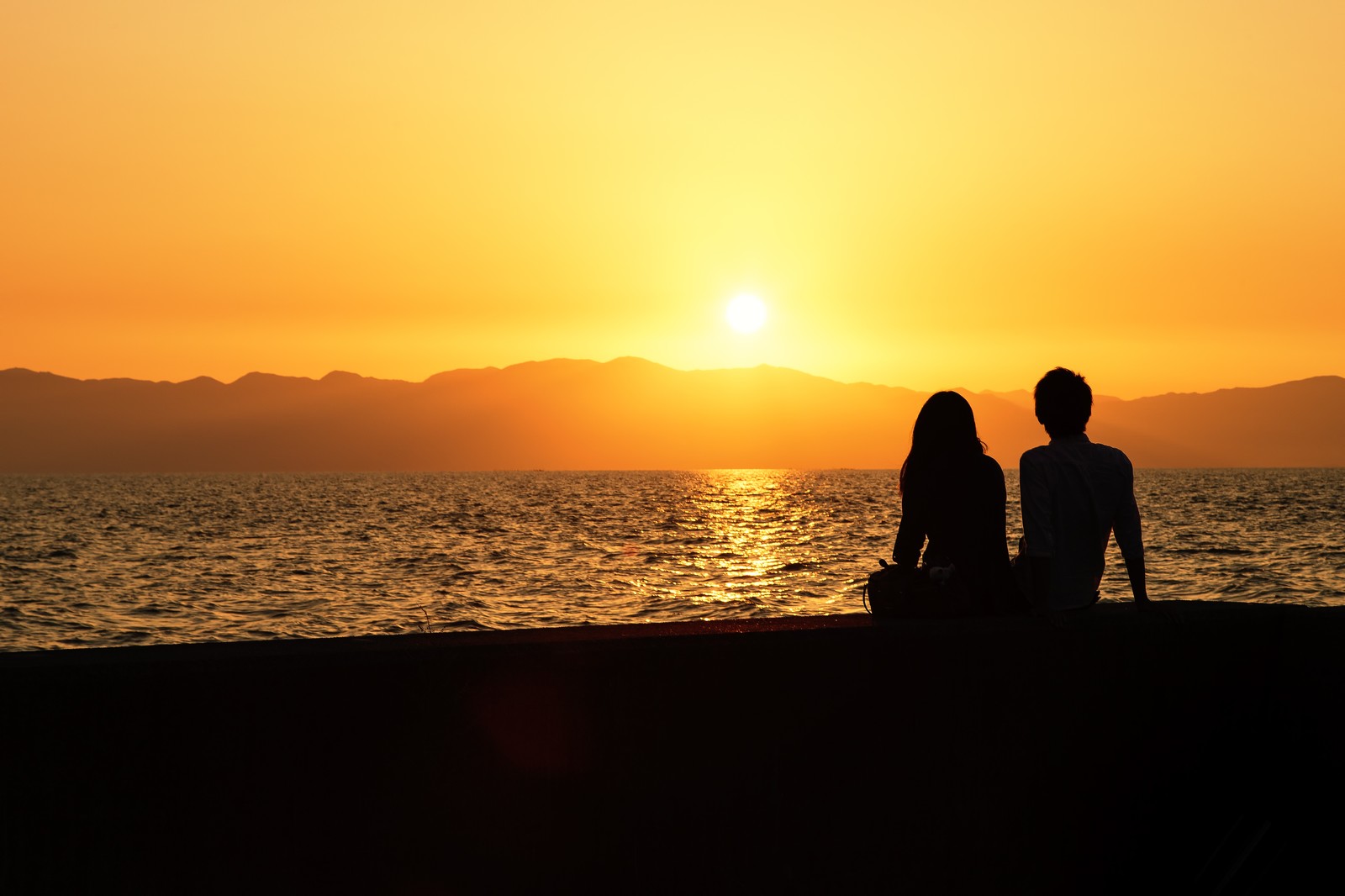 西表島で夕焼けを眺めるカップル